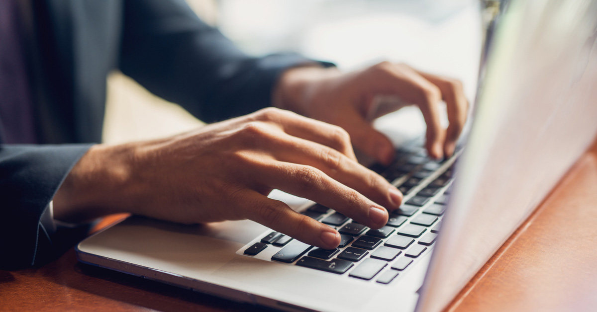 a person using a laptop computer sitting on top of a table