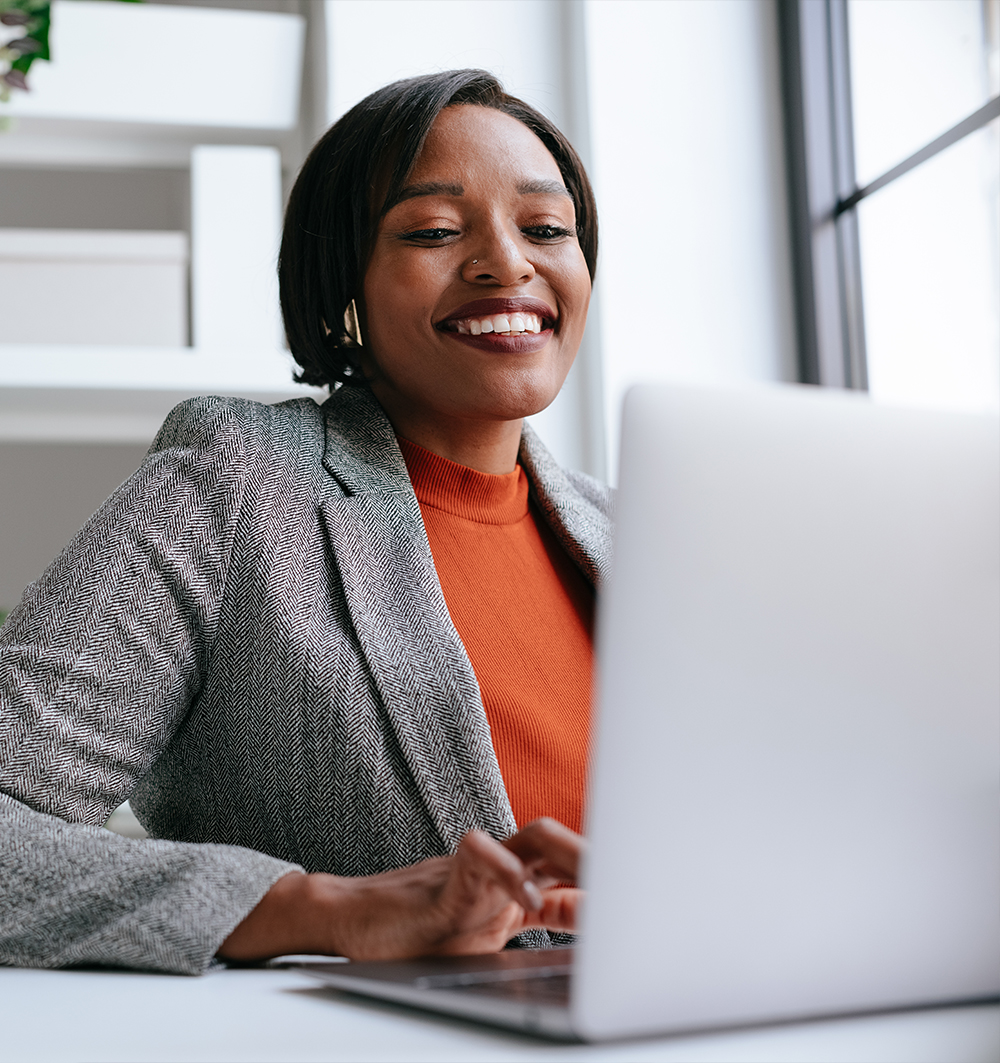a woman with a laptop and smiling at the camera